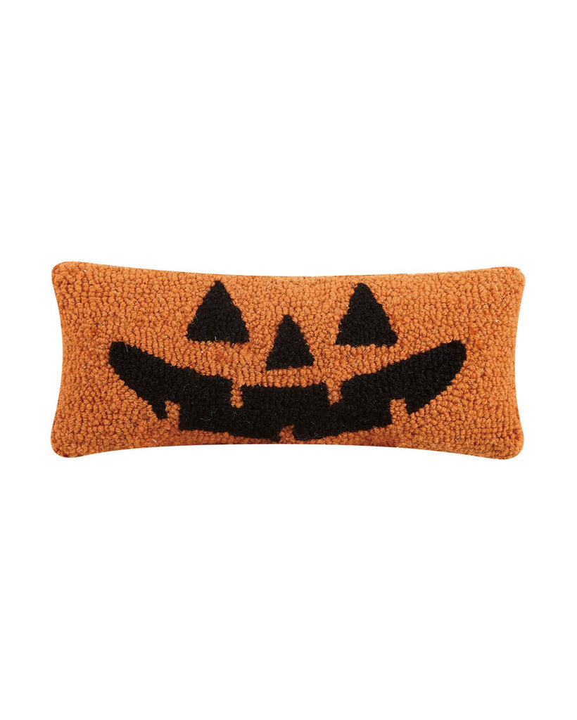 Rectangular pillow with a jack-o'-lantern face design on an orange background